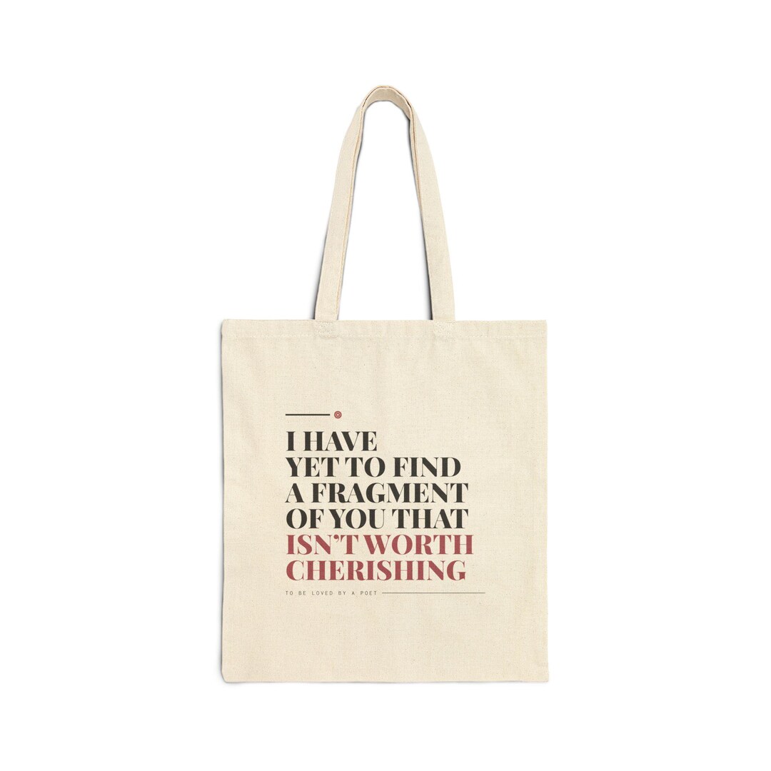 Natural cotton canvas tote bag printed with the poem line "I have yet to find a fragment of you that isn't worth cherishing"